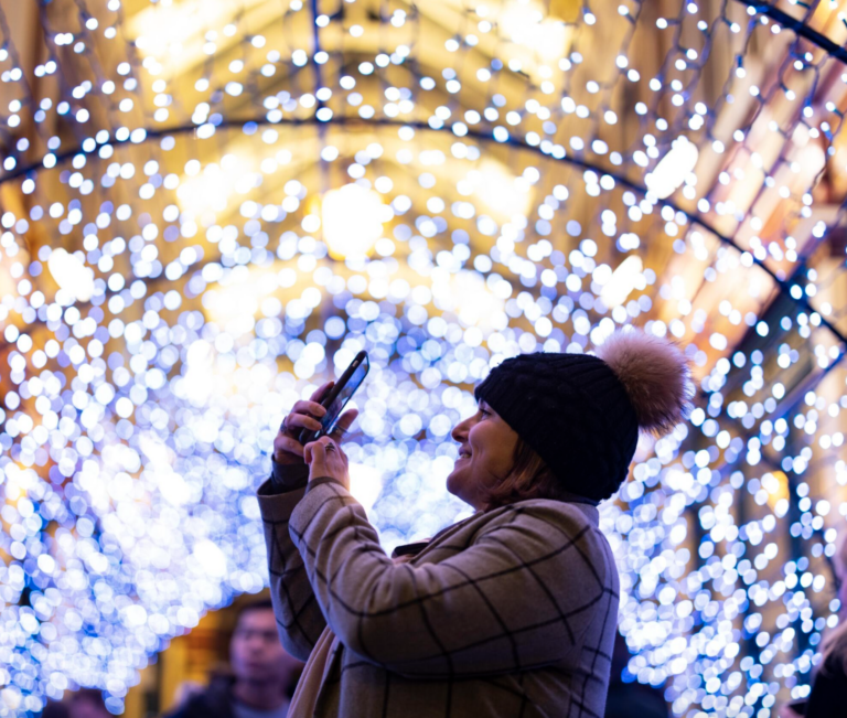 Lady taking photo of twinkling light tunnel at Leadenhall Market